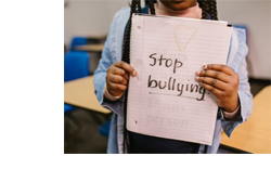 girl holding sign that says "Stopy Bullying"
