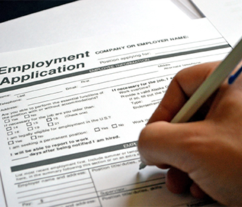 person filling out an employment form