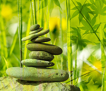meditation stones stacked in front of bamboo